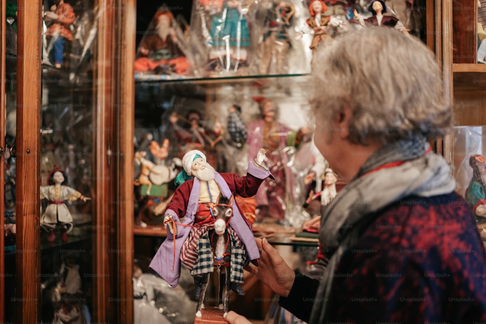 a woman looking at a collection of figurines