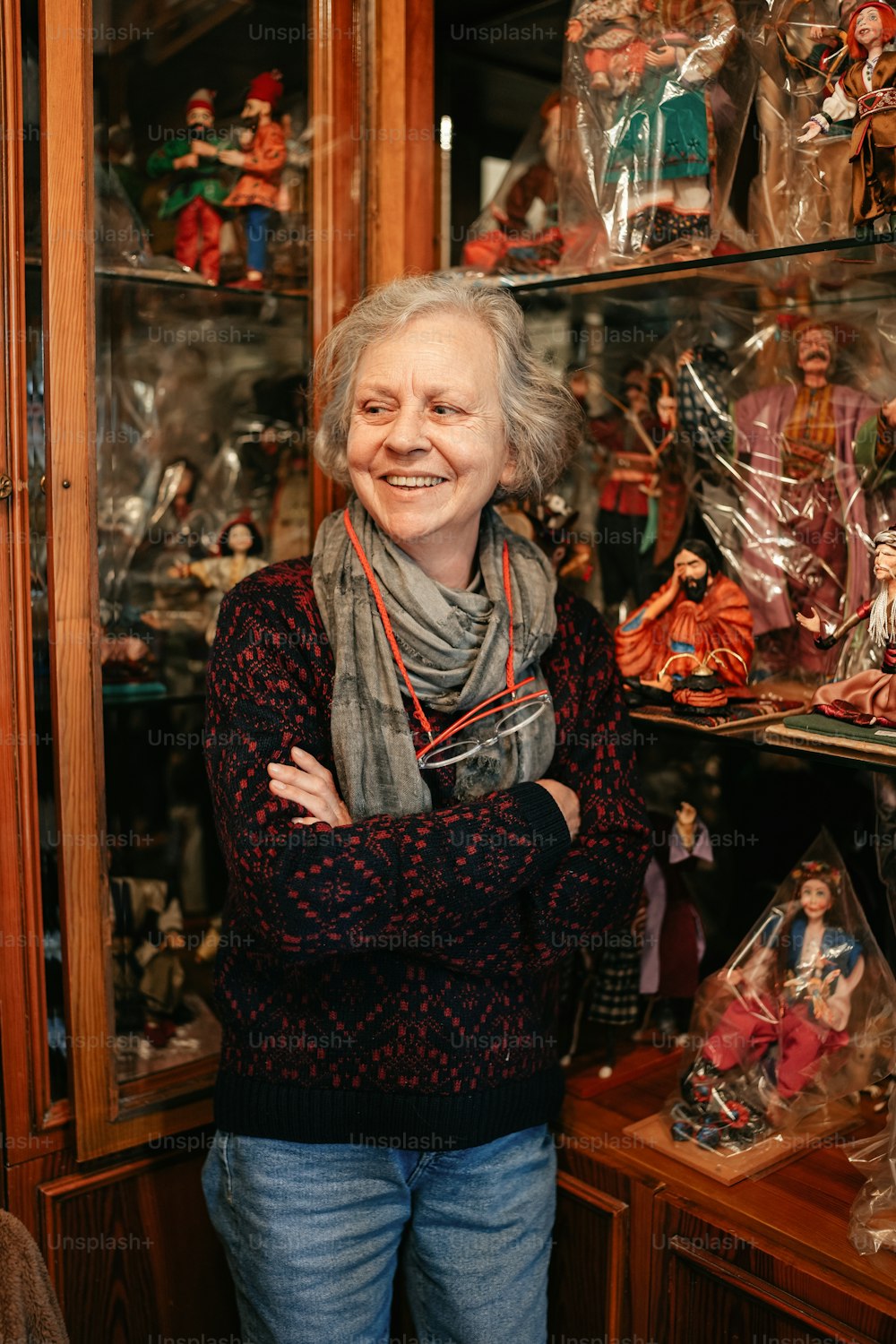 a woman standing in front of a glass case filled with figurines