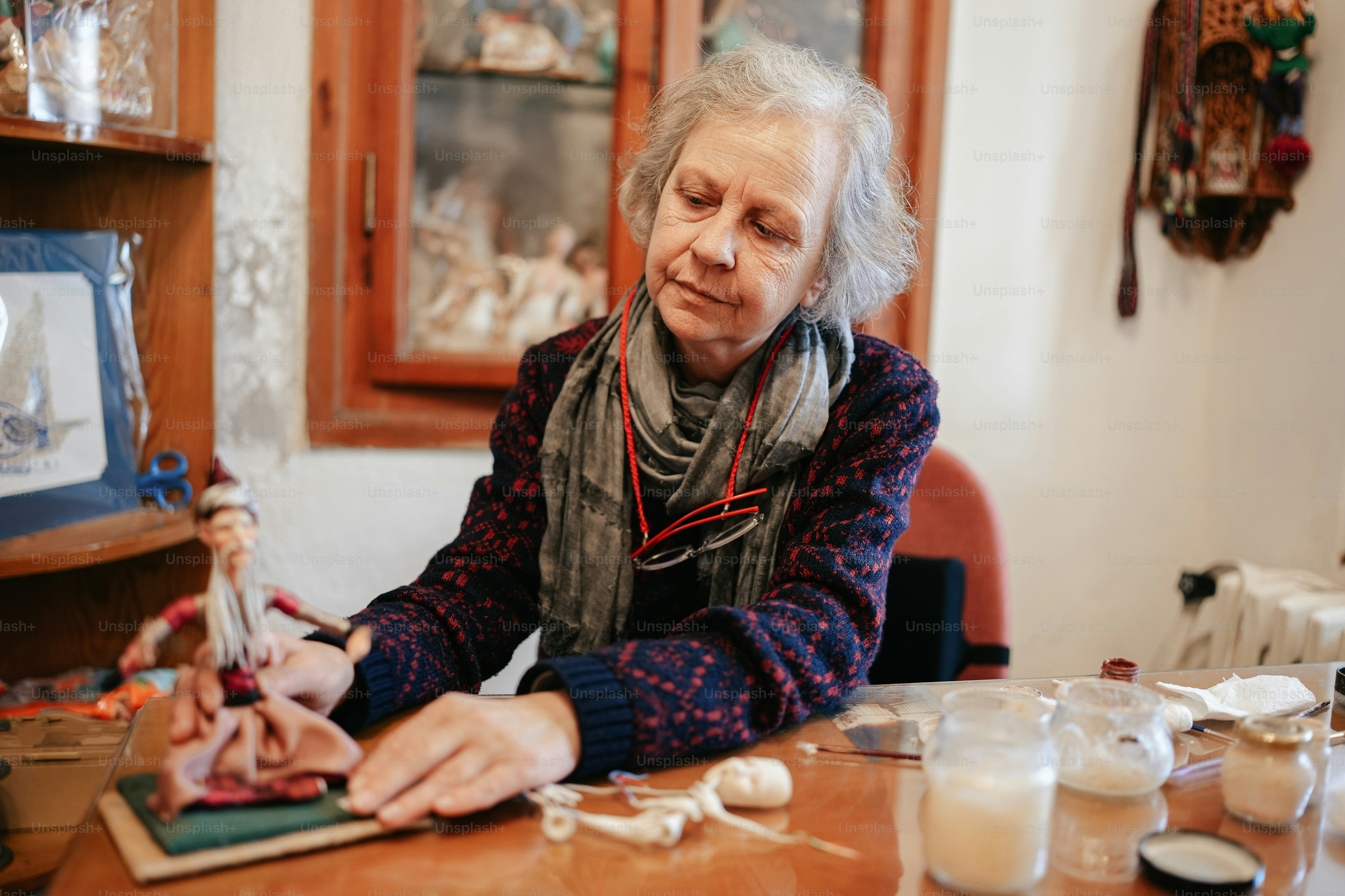 a woman sitting at a table with a doll