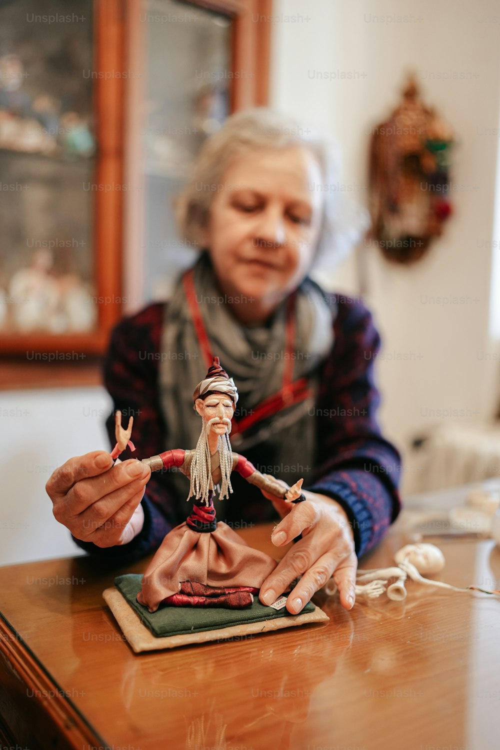 a woman holding a doll on top of a wooden table