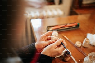 a person sitting at a table working on a craft project