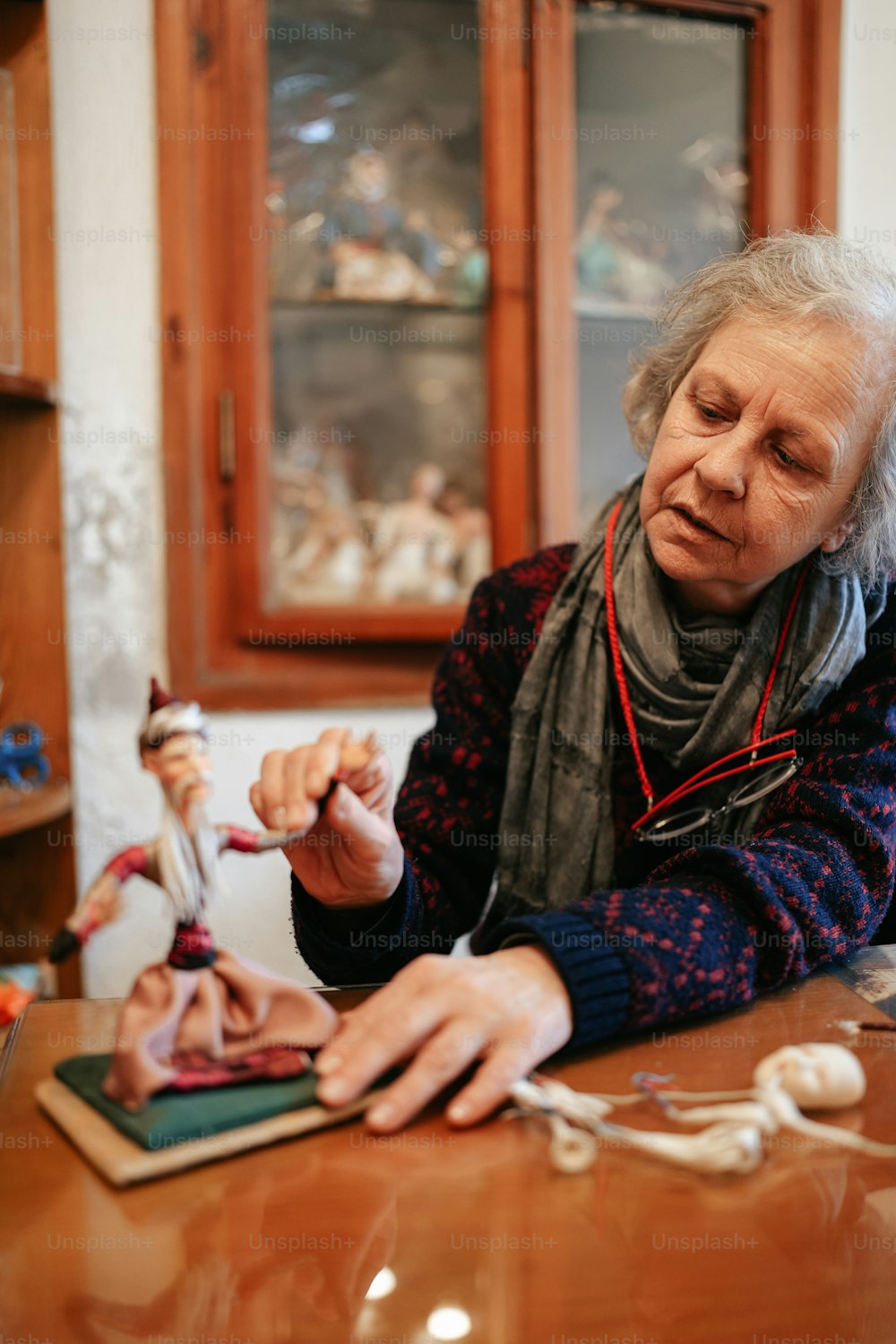a woman sitting at a table with a doll