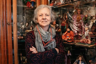a woman standing in front of a display case filled with figurines