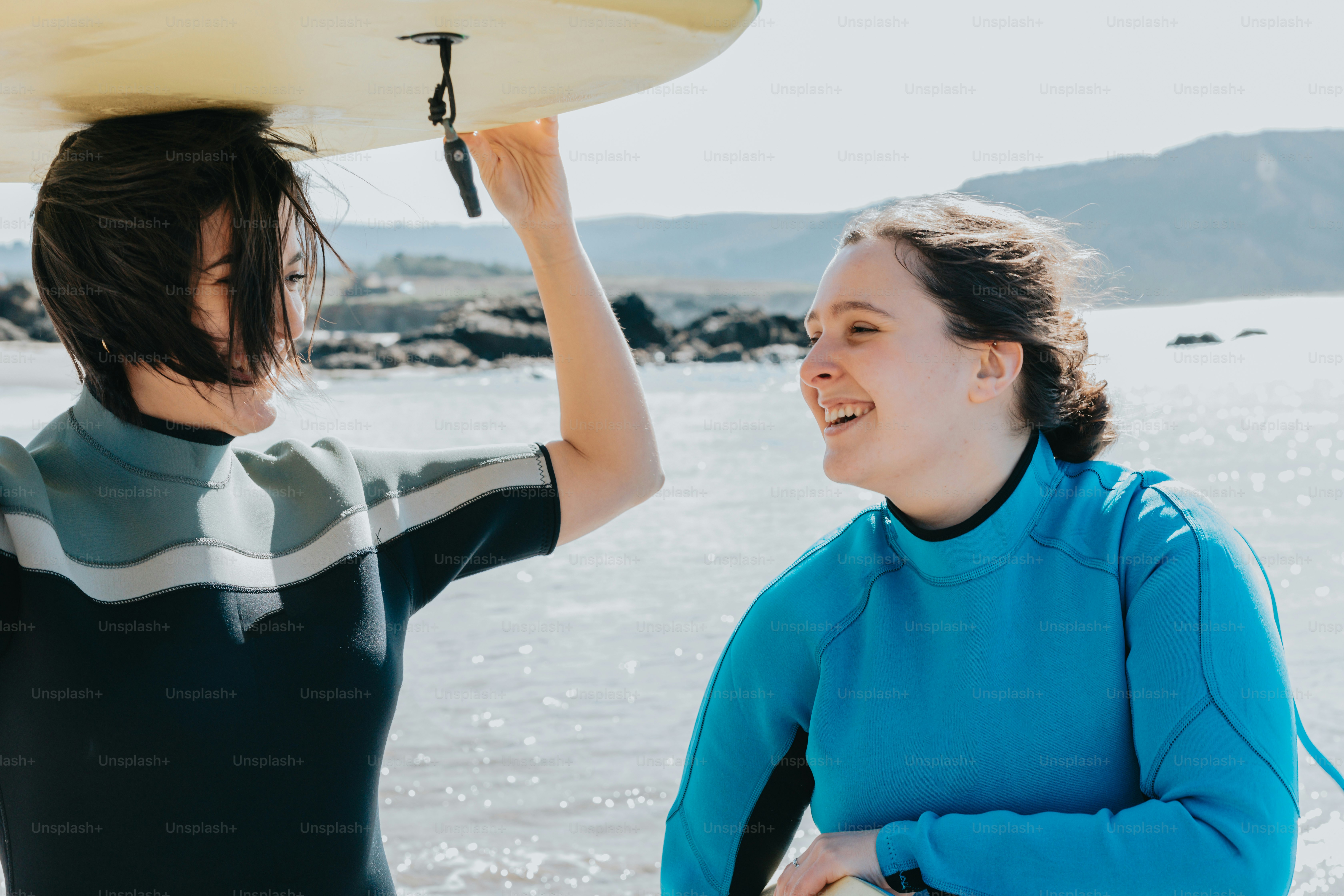 a woman holding a surfboard on top of her head