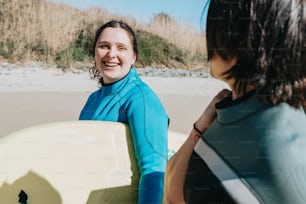 Una donna in una muta che tiene una tavola da surf