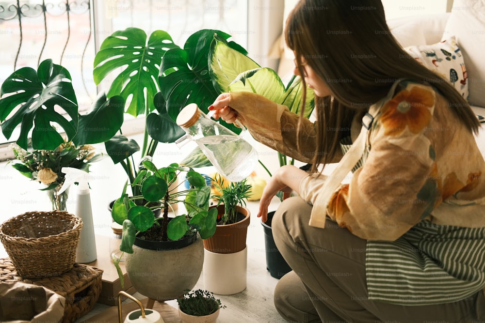 a woman sitting on a couch next to a potted plant