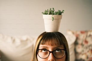a woman with glasses and a plant on her head