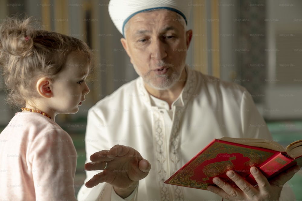 an older man reading a book to a little girl