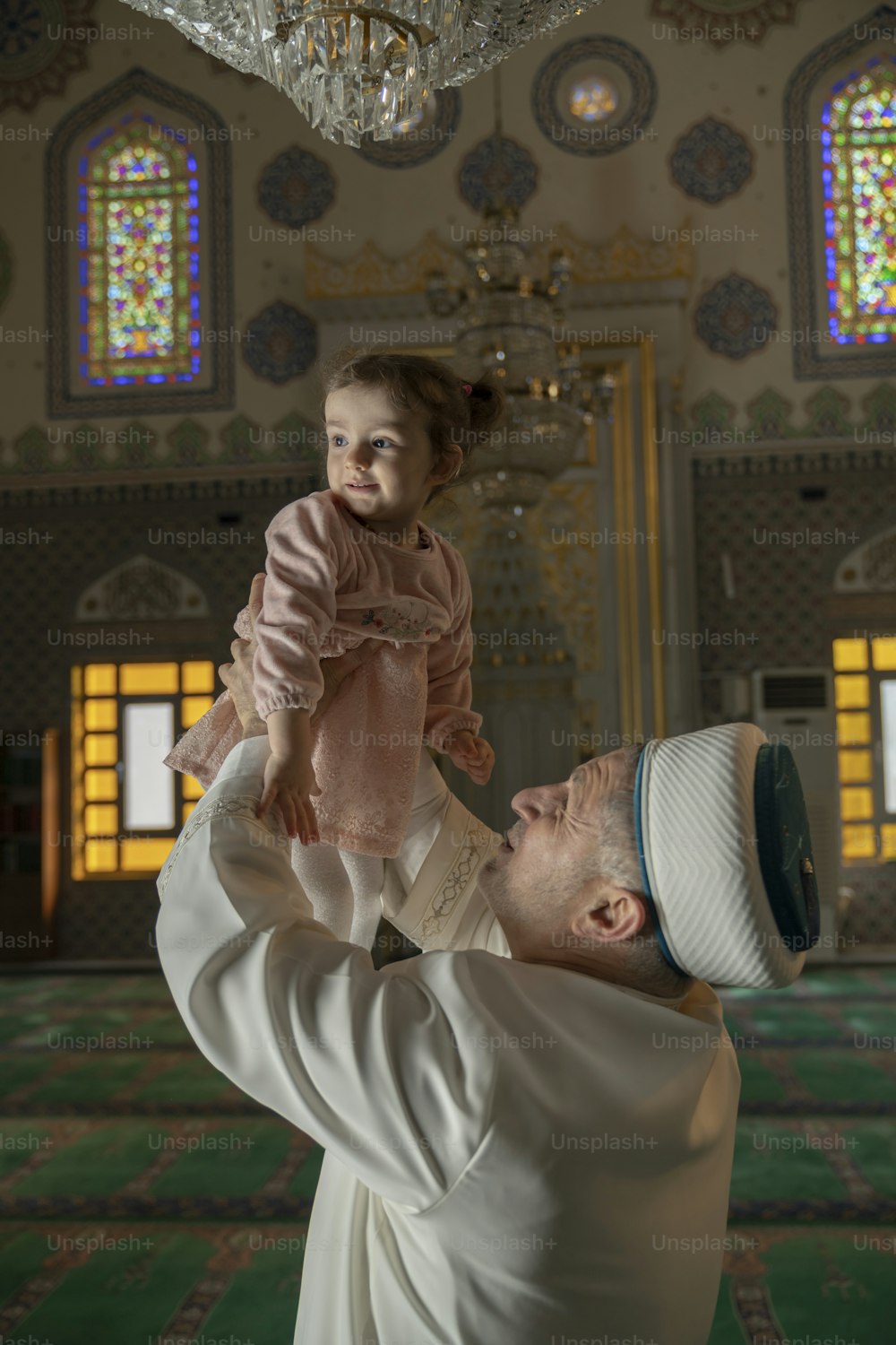a man holding a little girl up in the air