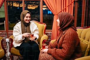 a woman sitting on a couch talking to another woman