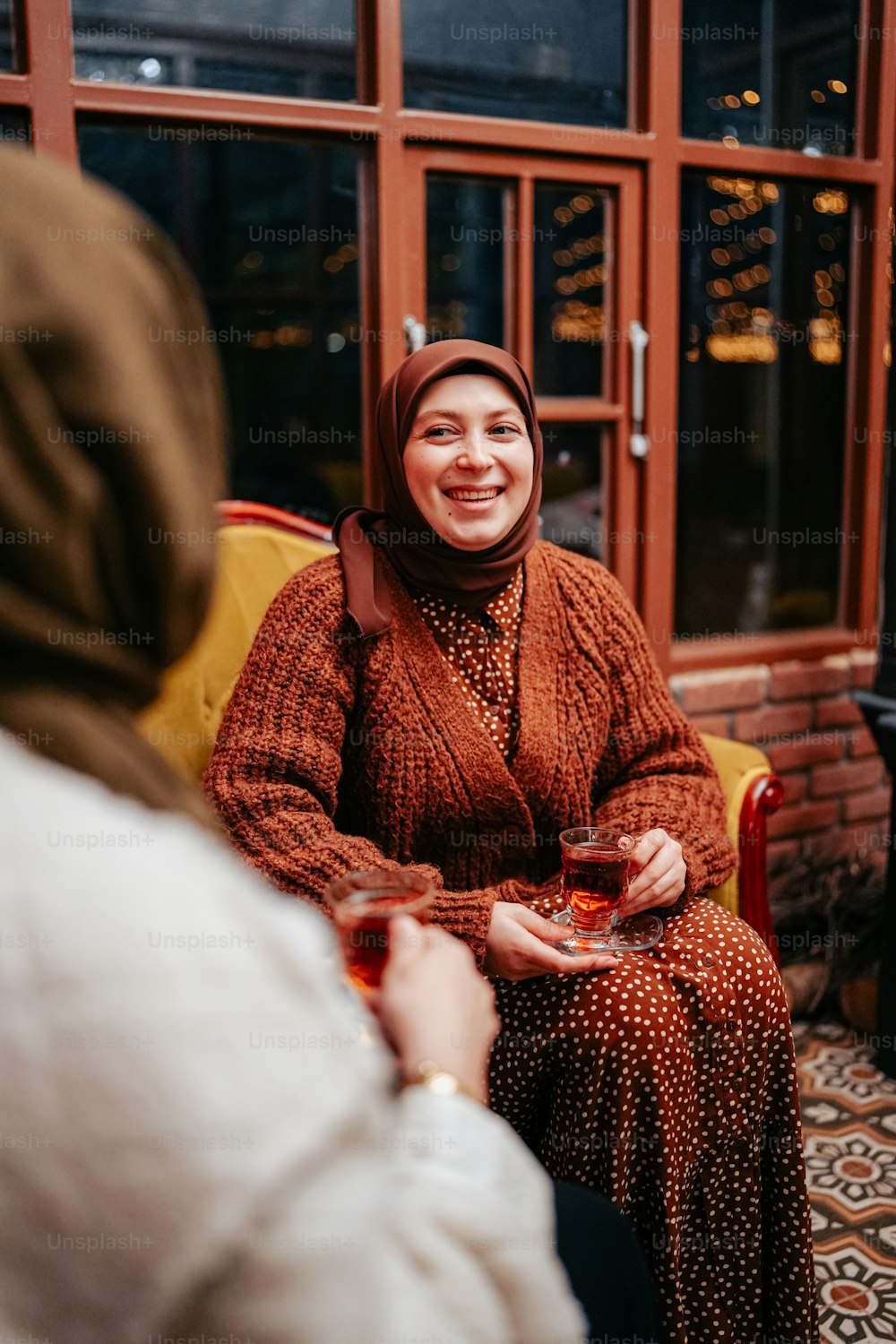 a woman sitting in a chair holding a glass of wine