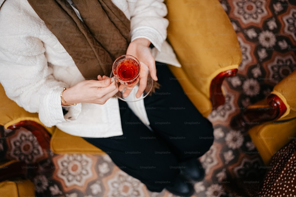 a woman sitting on a couch holding a glass of wine