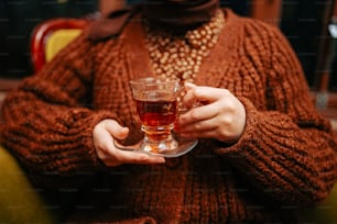 a woman holding a glass of wine in her hands