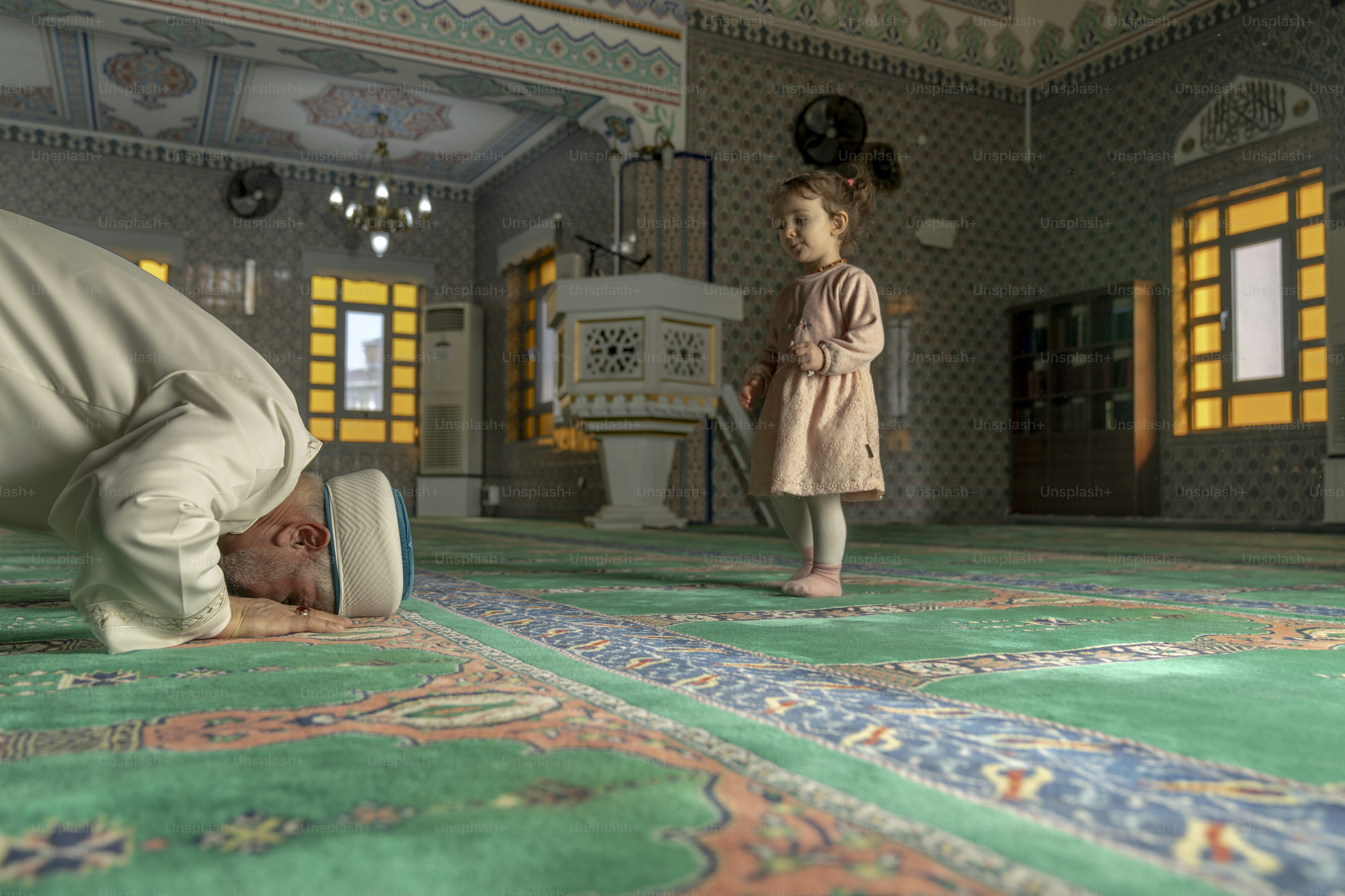Una bambina in piedi accanto a un uomo su un tappeto