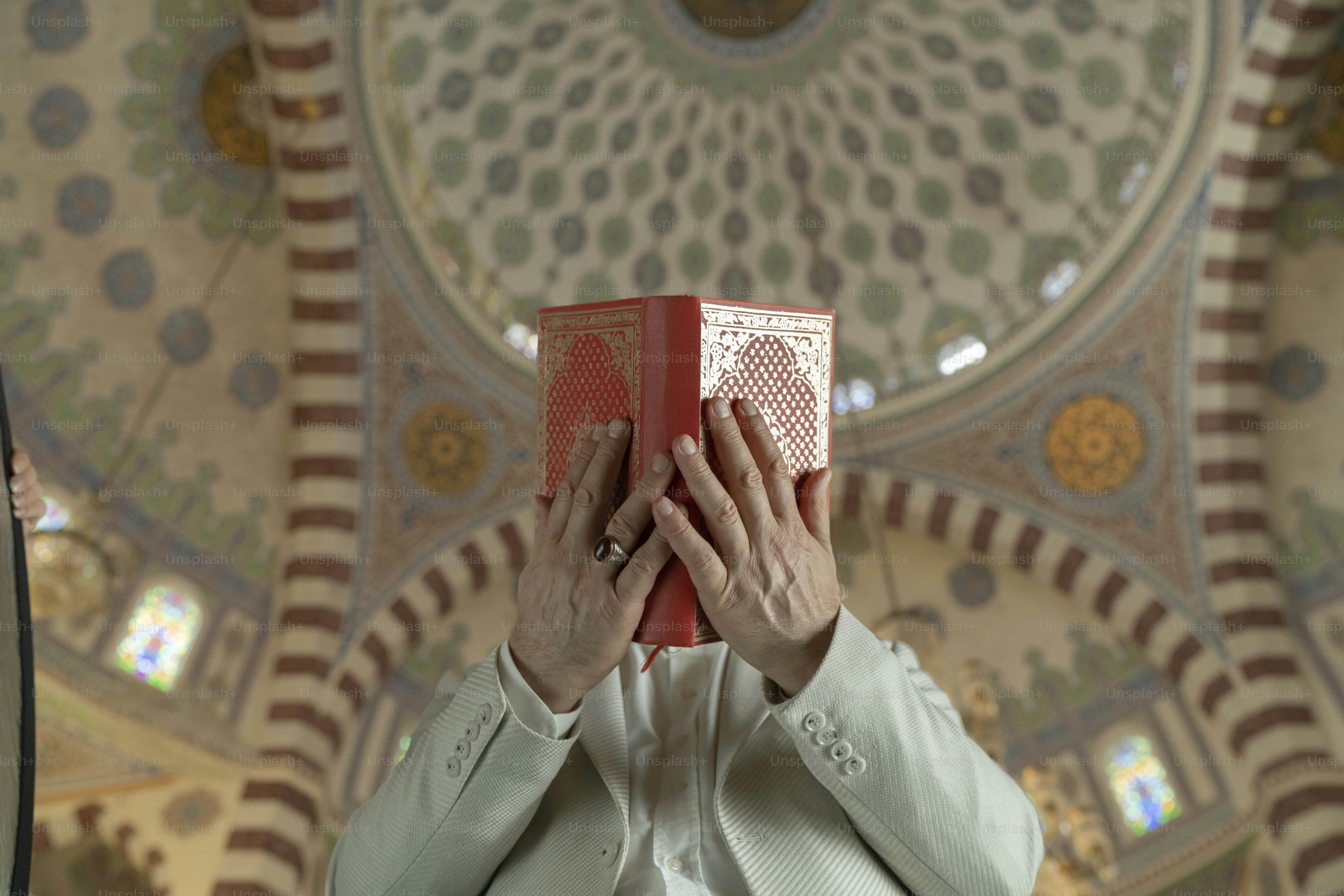 A woman holding a red book in front of her face photo – Man Image on ...