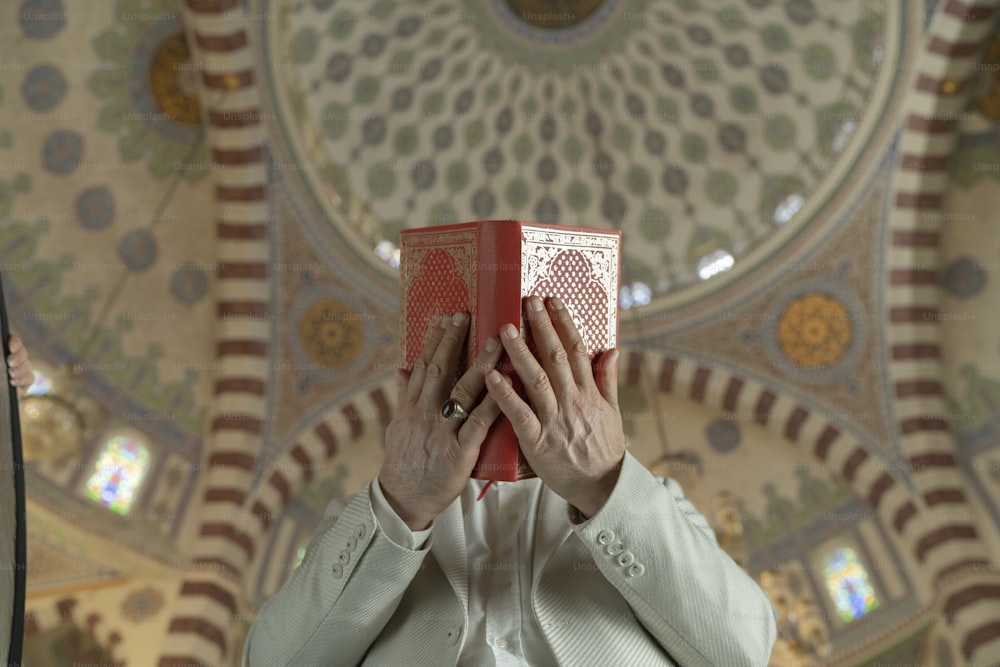 a woman holding a red book in front of her face