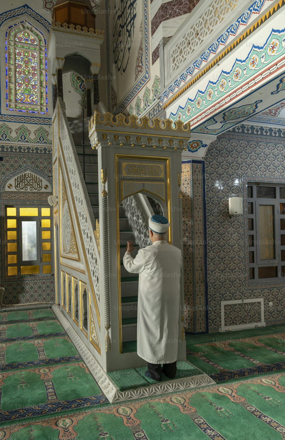 a man in a white coat is standing at the top of a stair case