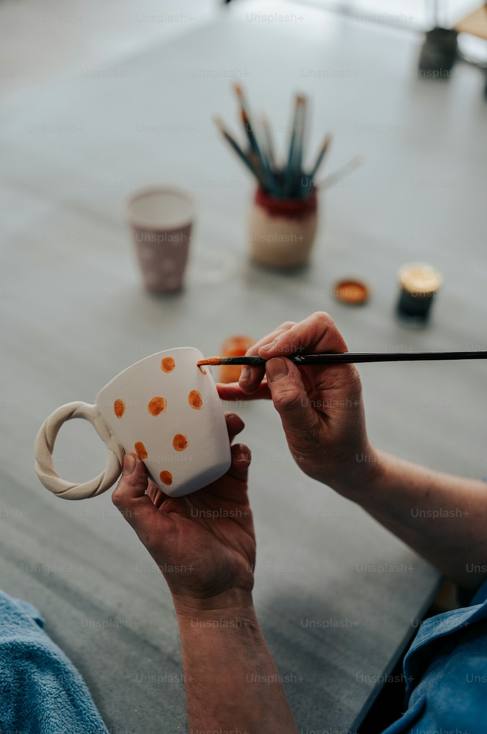 Una persona pintando una taza con un pincel