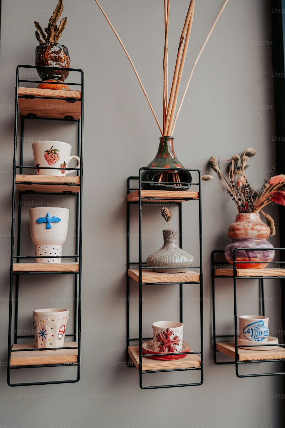 three shelves with vases and other items on them