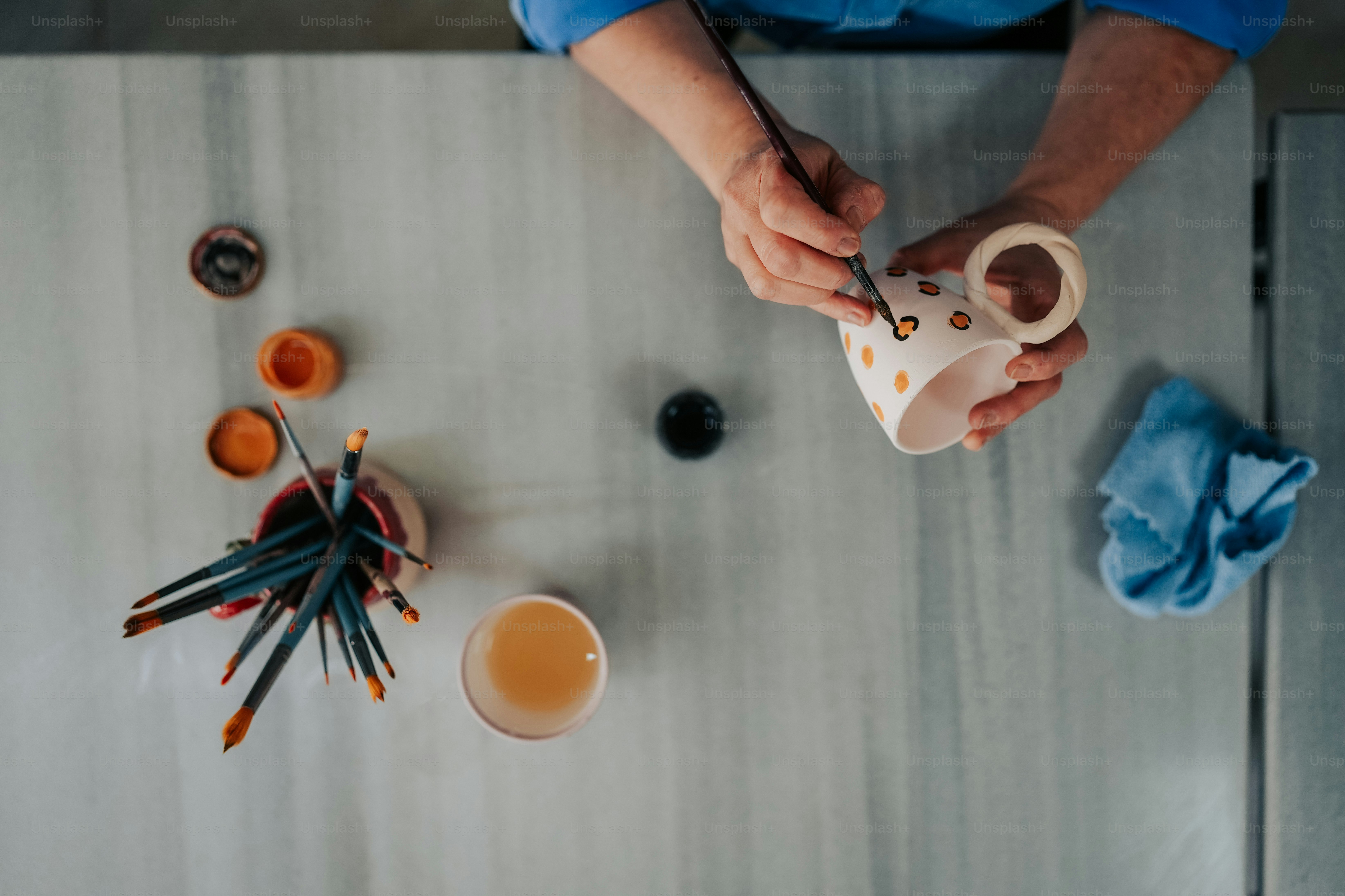 a person holding a cup over a table