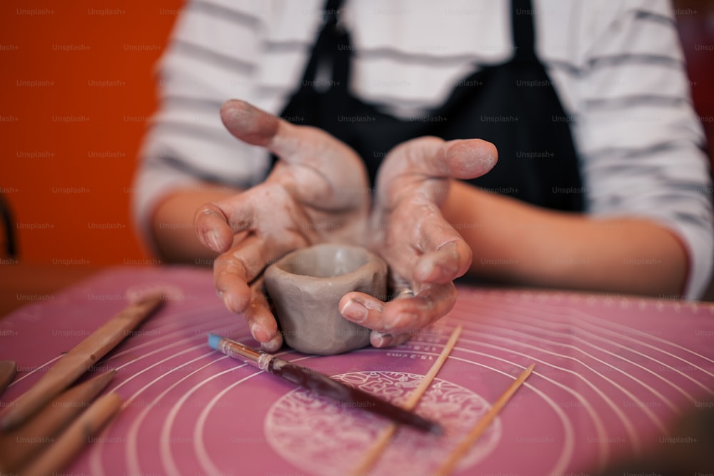 a person making a vase out of clay