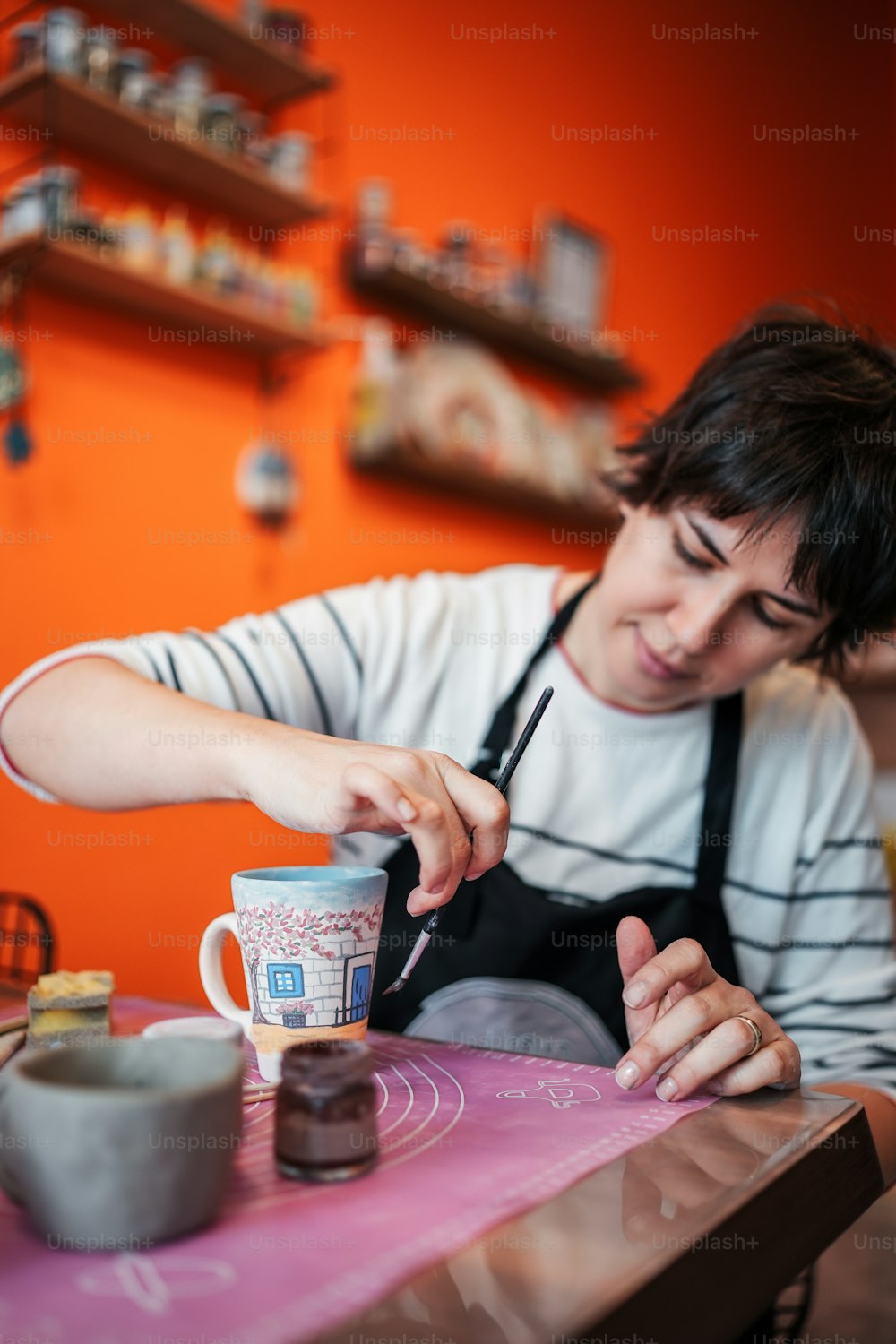 a woman sitting at a table with a cup of coffee