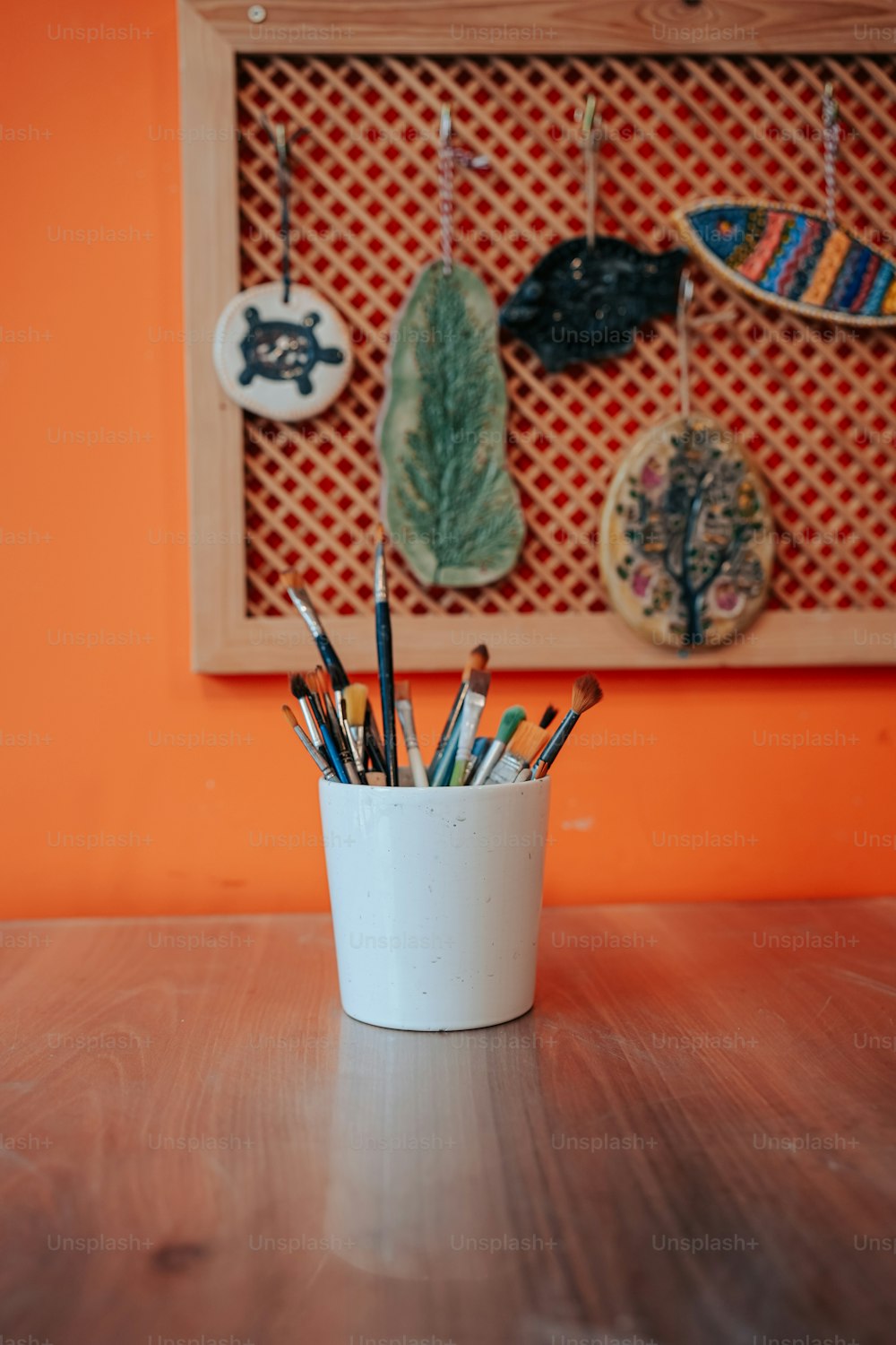 a cup filled with pencils sitting on top of a wooden table