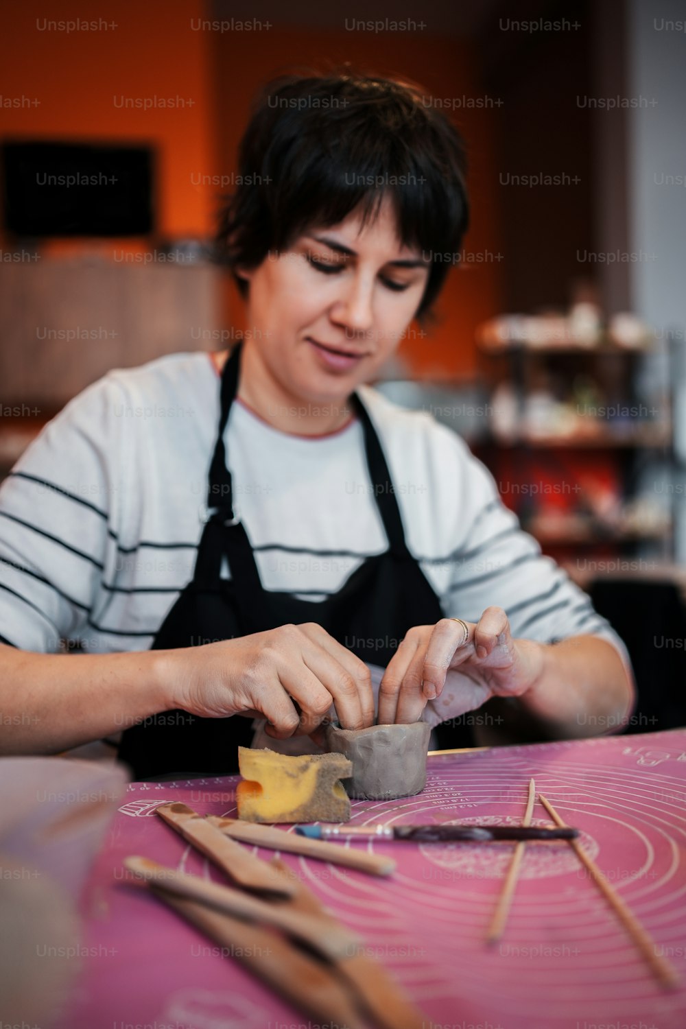 a woman in an apron working on a piece of food