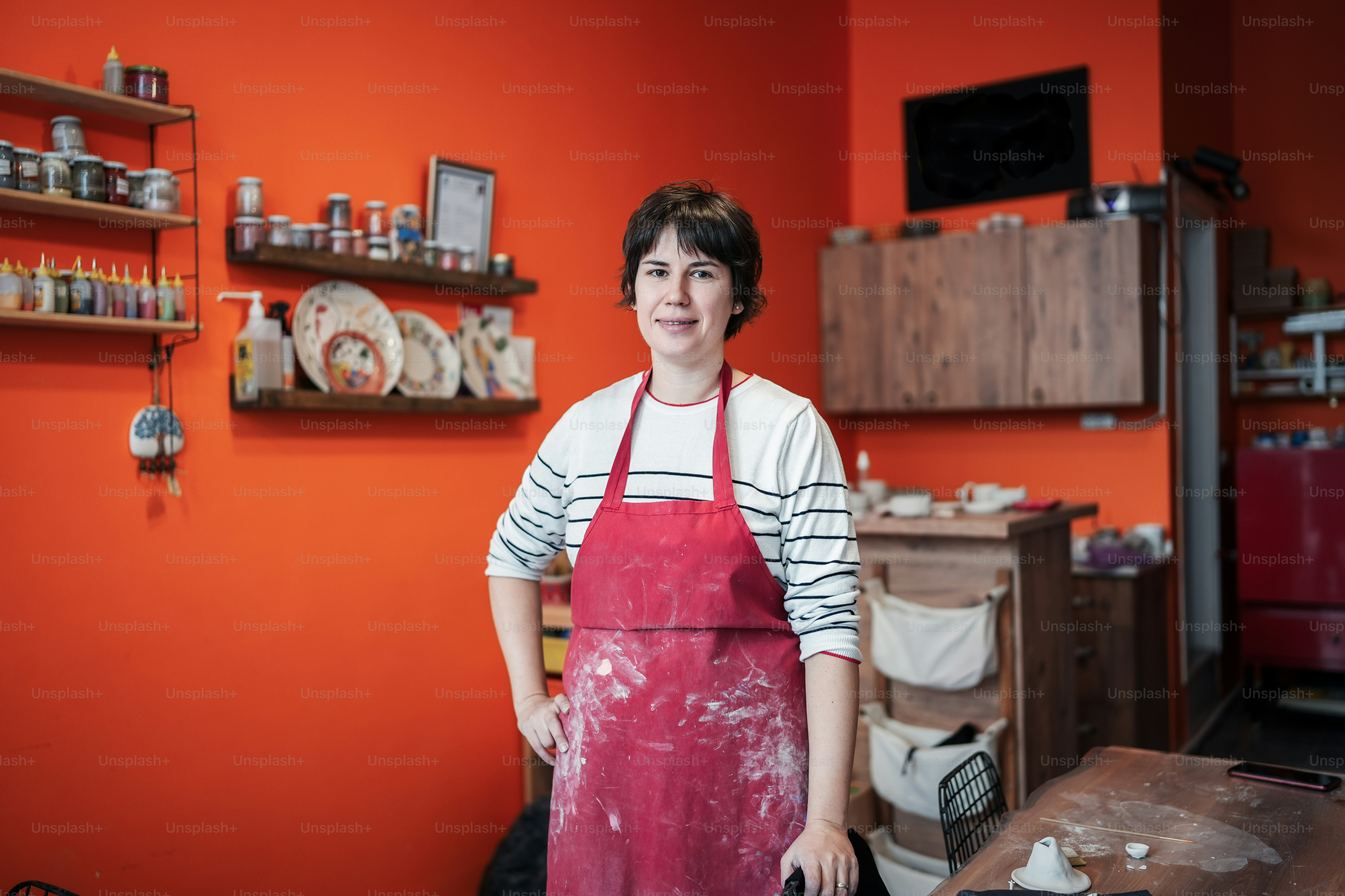 a woman in a red apron standing in a kitchen