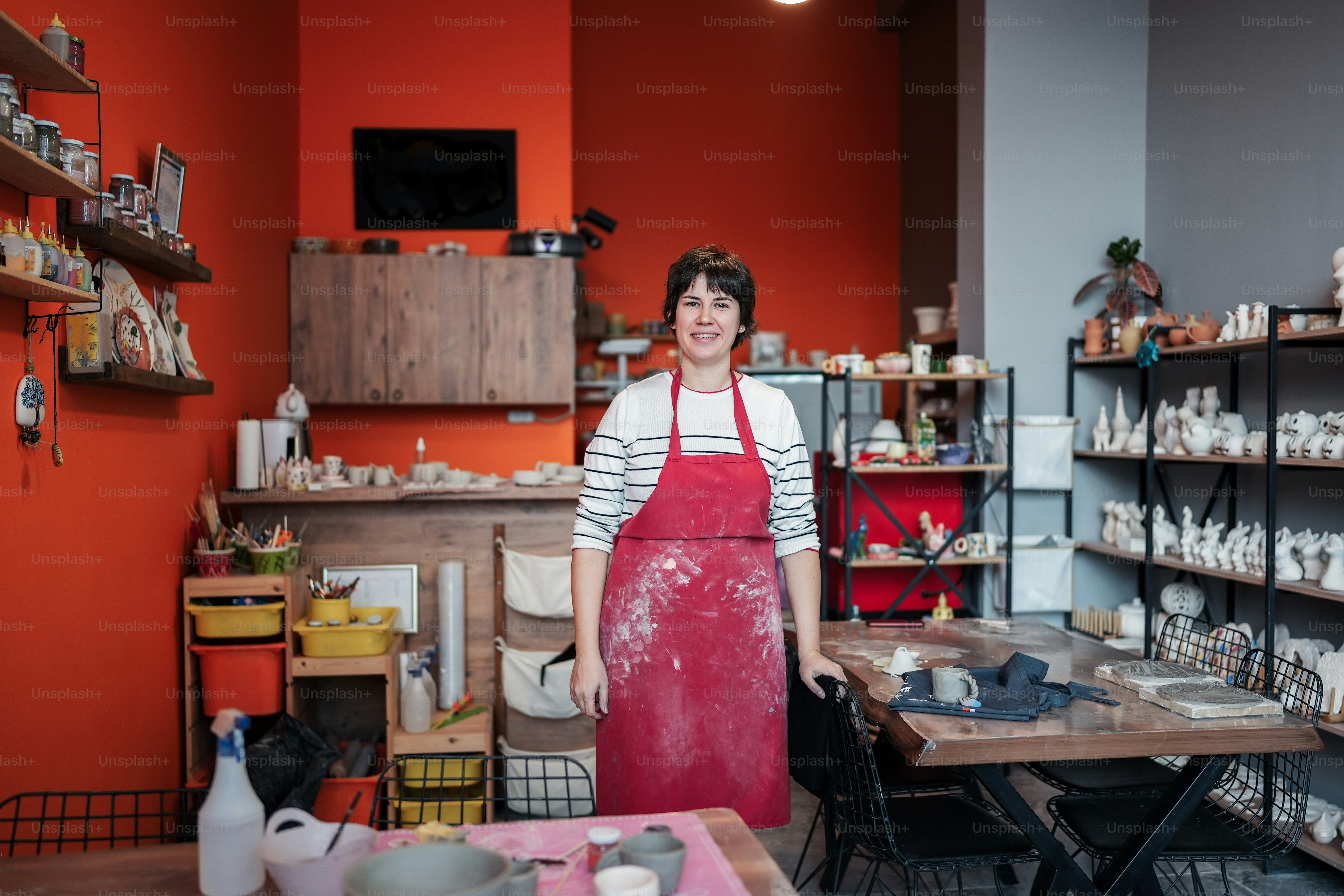 a woman standing in a room with a red apron
