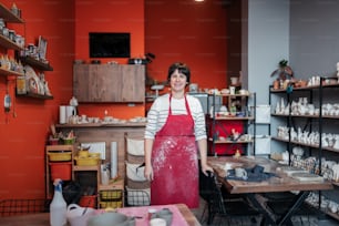 a woman standing in a room with a red apron