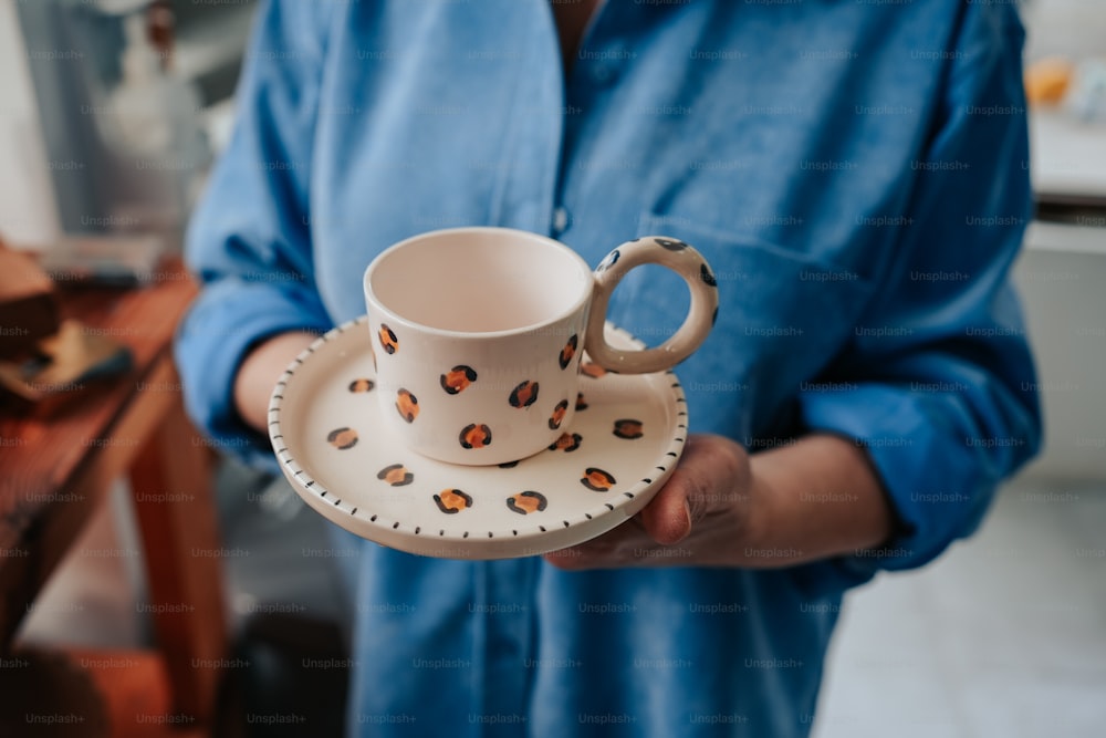 a person holding a coffee cup and saucer
