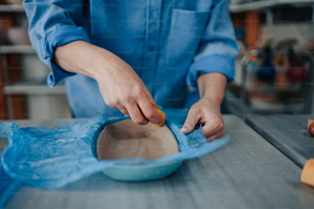 a person in a blue shirt is making a bowl