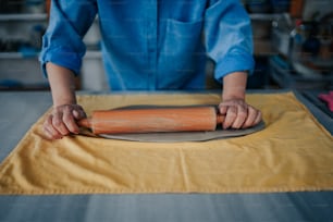 a person rolling out a dough on a table