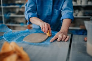 a person in a blue shirt is kneading a doughnut