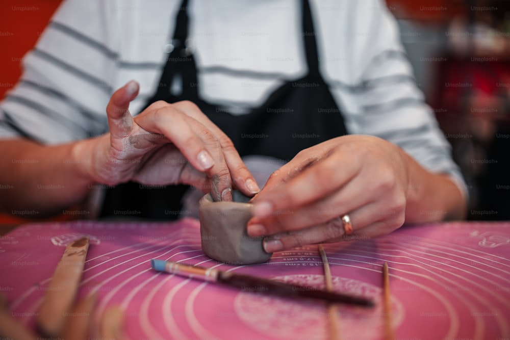 eine Person, die an einem Stück Keramik arbeitet