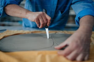 a person cutting a piece of cement with a knife