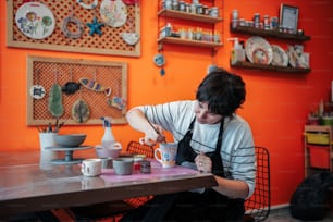 a woman sitting at a table with cups and saucers