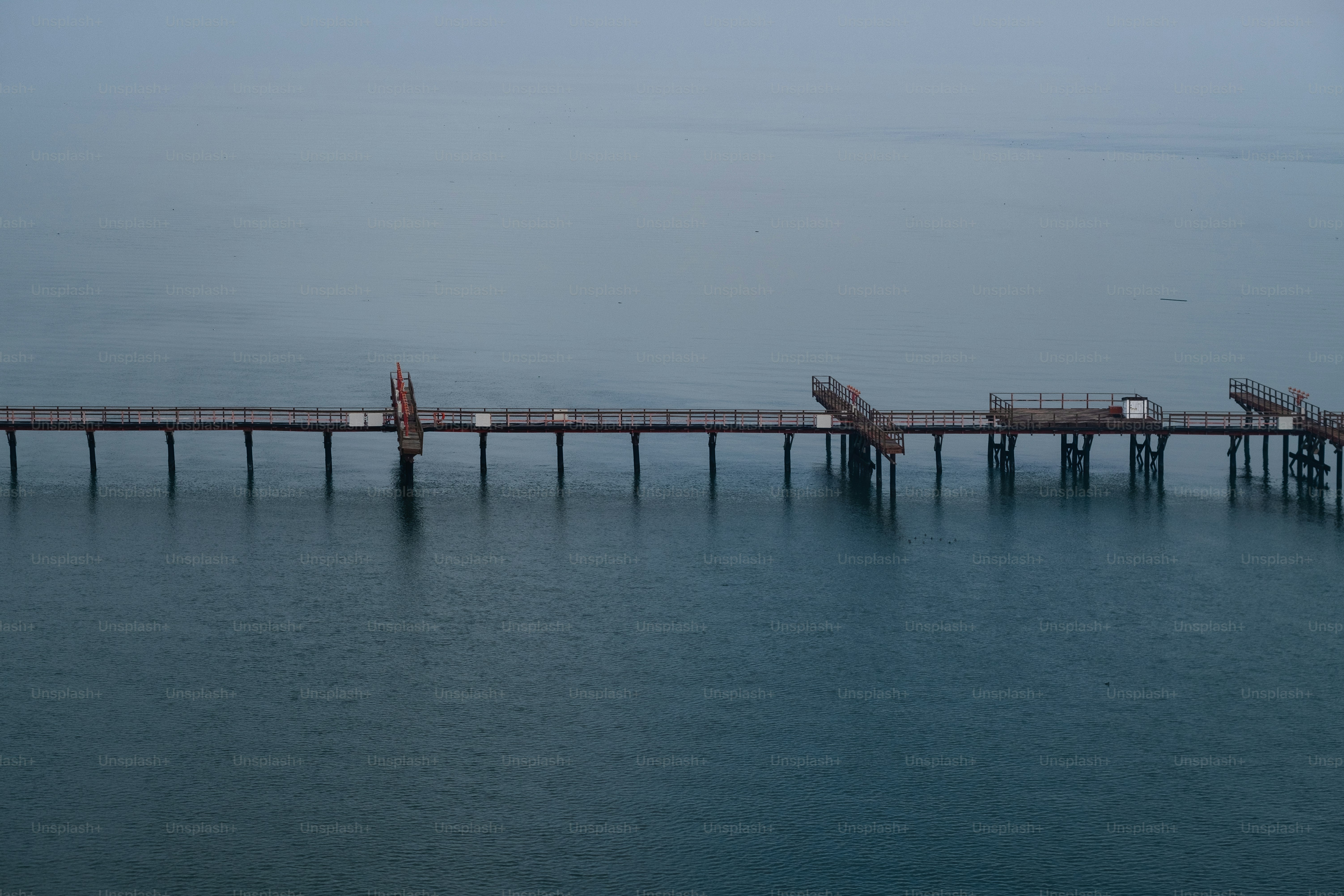 a long pier stretches out into the ocean