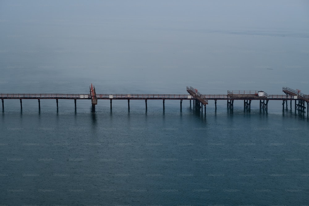 a long pier stretches out into the ocean