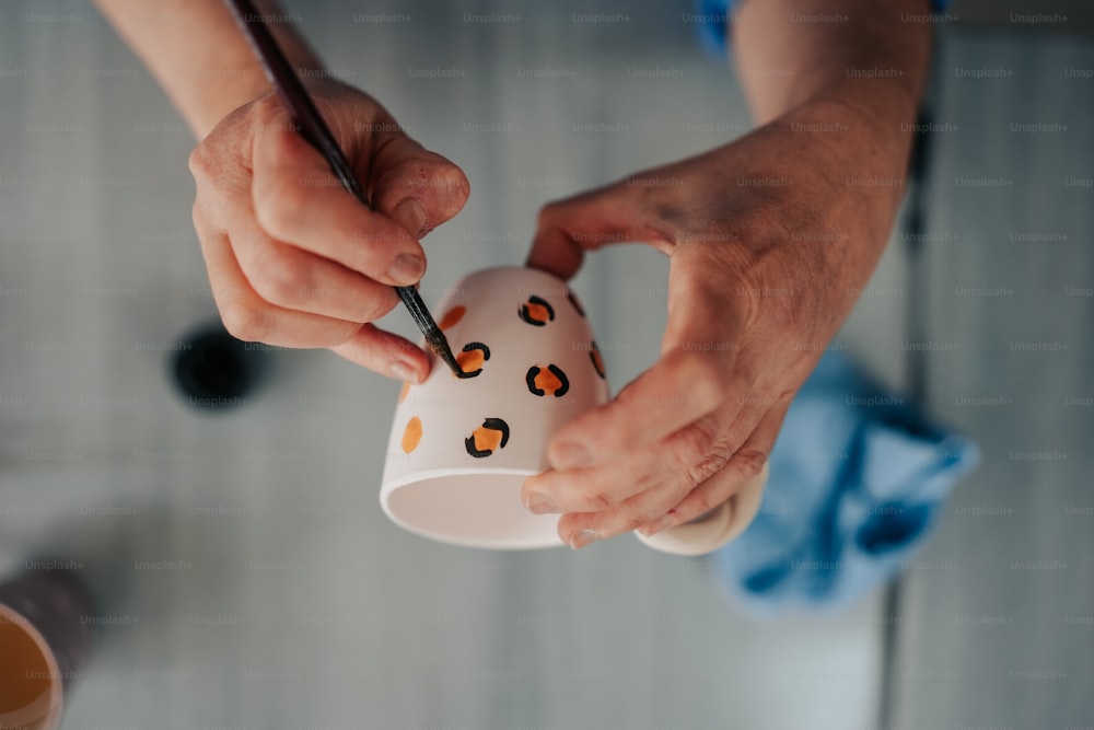 Una persona sosteniendo una taza de café con un diseño