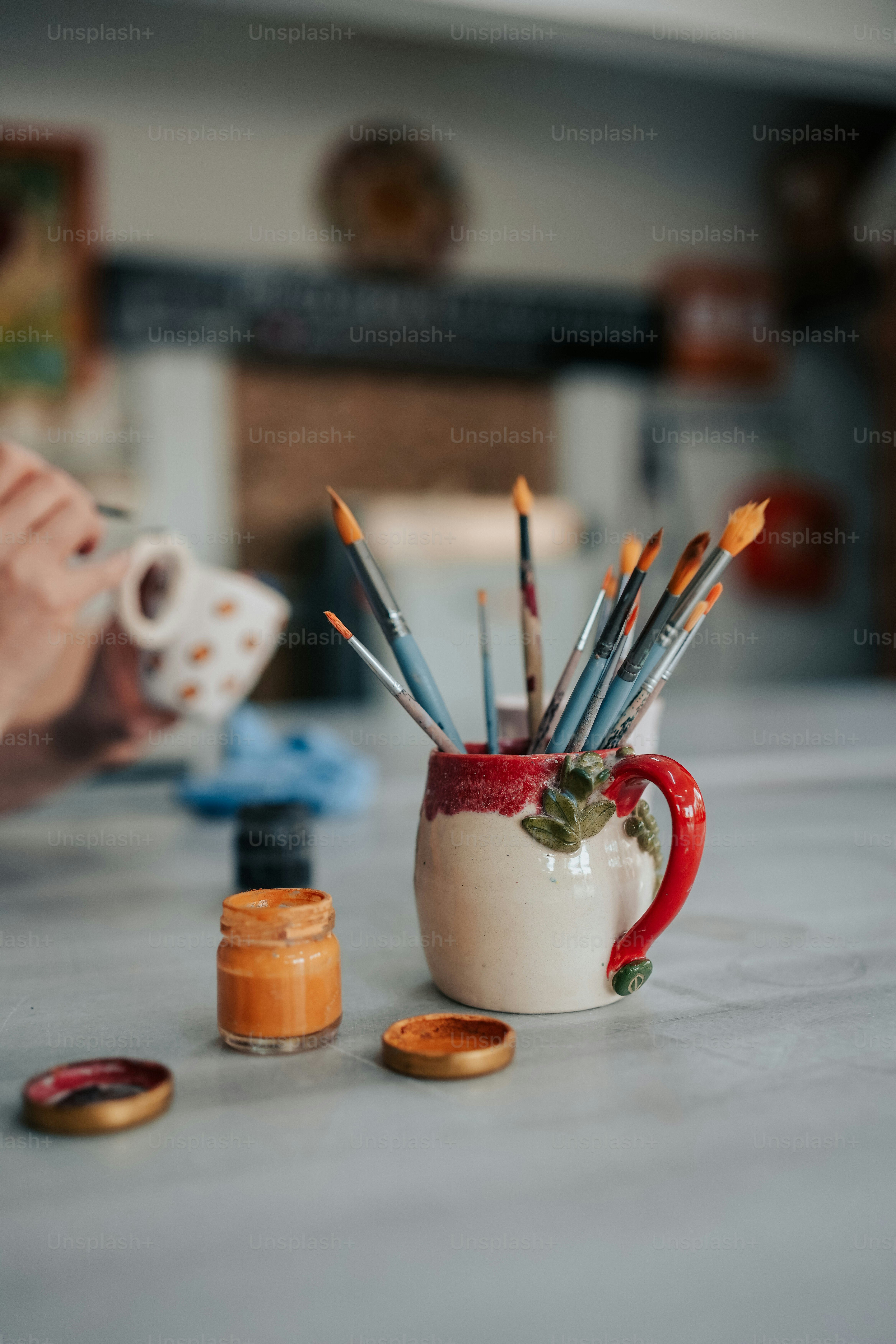 a coffee cup filled with lots of paint brushes