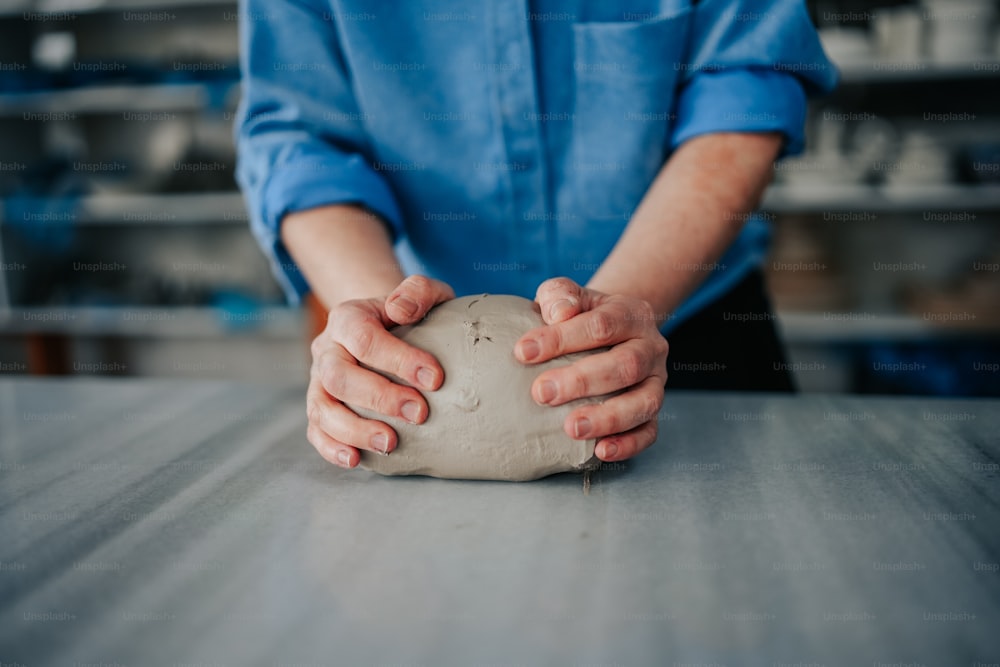 a person holding a ball of dough on a table