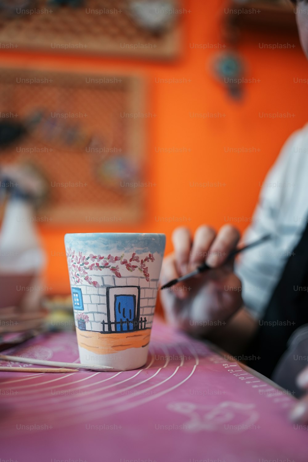 uma pessoa sentada em uma mesa com uma xícara de café