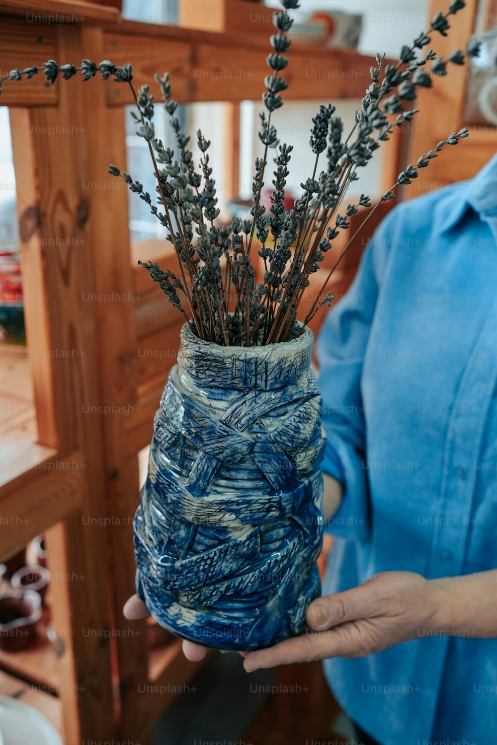eine Person, die eine Vase mit Blumen darin hält