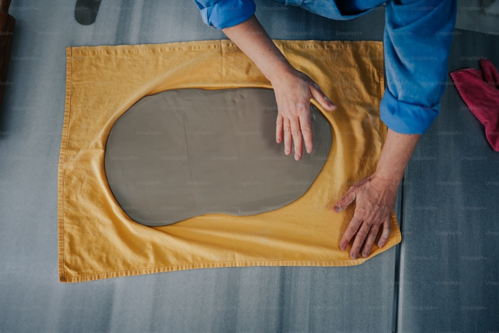una persona sta facendo un oggetto rotondo da un foglio di stoffa