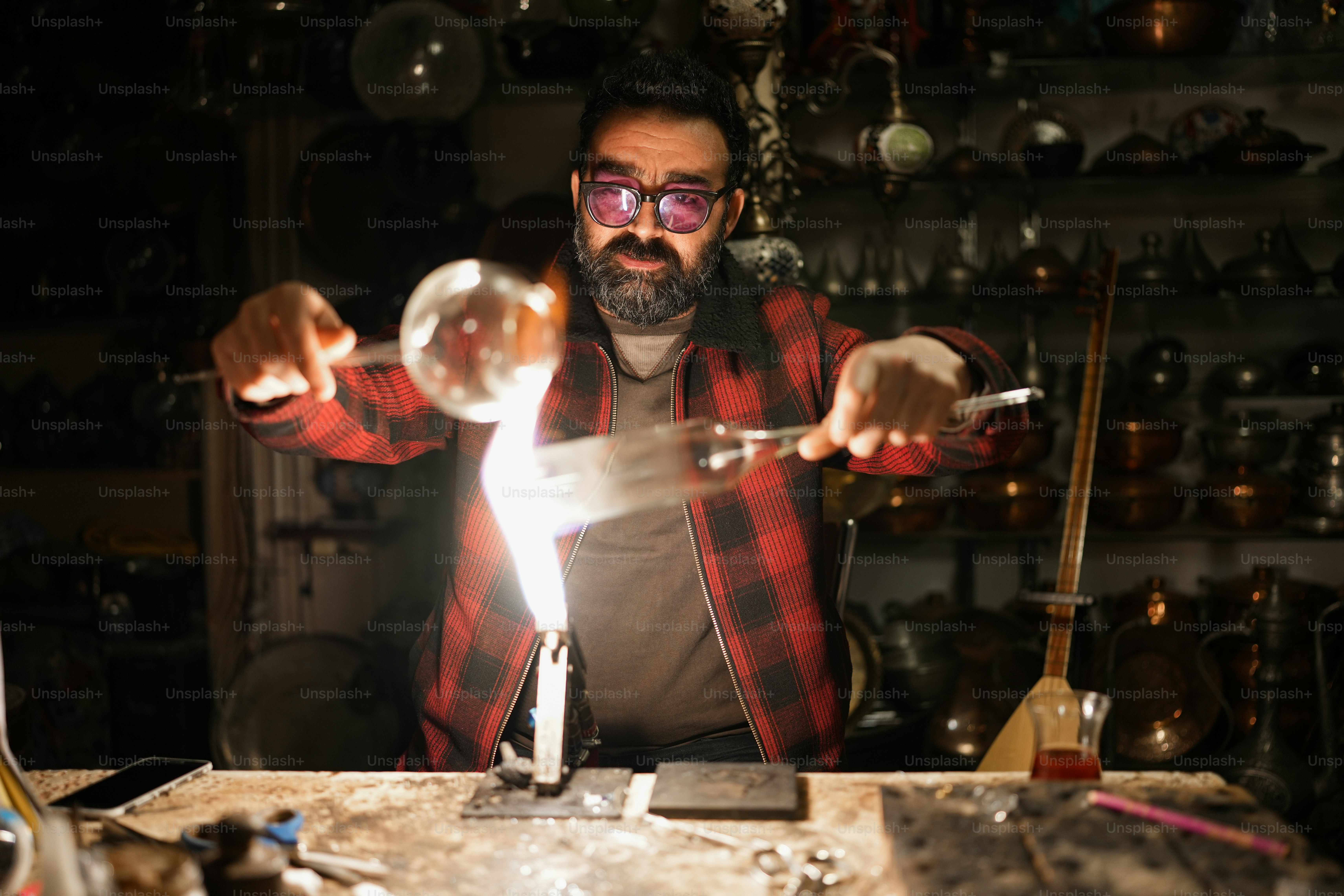 a man in a red and black checkered shirt holding a glass ball