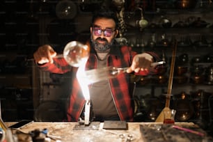 a man in a red and black checkered shirt holding a glass ball