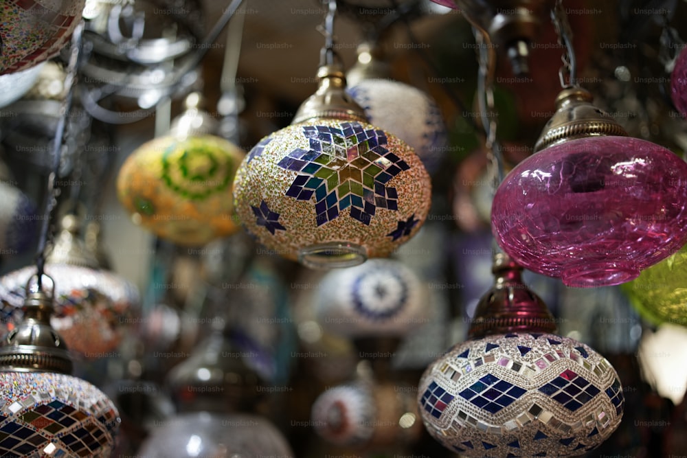 a bunch of different colored ornaments hanging from a ceiling