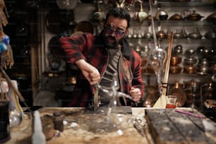 a man in a shop making a glass vase